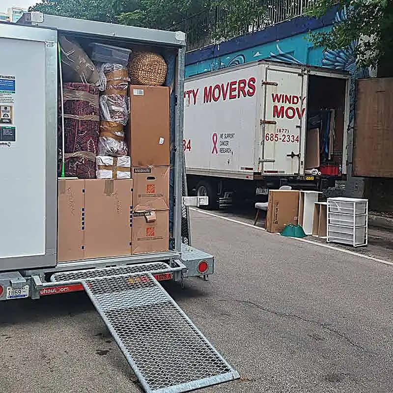 Movers loading items from a brick building